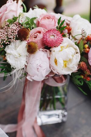 Wedding bouquet with white and pink rose, peonies and greenery standing on wooden balcony.close up.の写真素材