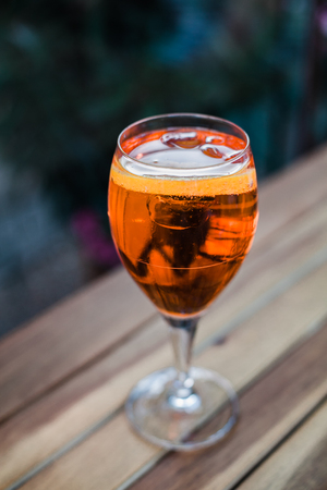 Aperol spritz cocktail in glass on wooden table on dark background in cafeの写真素材