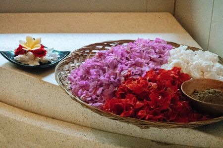 Violet, red and white petals in silver bowl on stone background. Details for bath. Spa,organic and skin care, beauty treatment concept.の写真素材