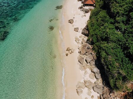 Aerial drone view of tropical island with white beach and blue clear water and jungle. Bali...