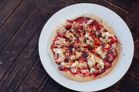 Incredibly delicious strawberry pizza . Pizza with strawberries . Original pizza with cheese and strawberries on wooden table.top viewの写真素材