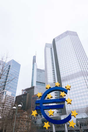 FRANKFURT-AM-MAIN, GERMANY - MARCH 2020: Euro neon sculpture sign in front of the ECB Eurotower in rainy fog weather.のeditorial素材