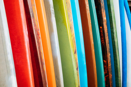 Close up Set of colorful surfboard for rent on the beach. Multicolored surf boards different sizes and colors surfing boards on stand, surfboards rental placeの写真素材