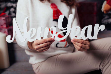 New Year text in wood type blocks in the hands of woman. New Year and Christmas conceptの写真素材