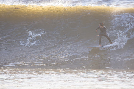Surfer in action on the ocean waves on a sunny day.