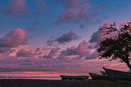 Fishing boats on the beach at sunset in Bali, Indonesiaの写真素材