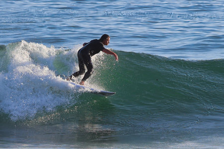 Fisheye lens shot of a man surfing the wave in Ovar, Portugal.