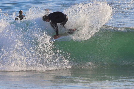 Surfer in action on the ocean wave on a sunny day.