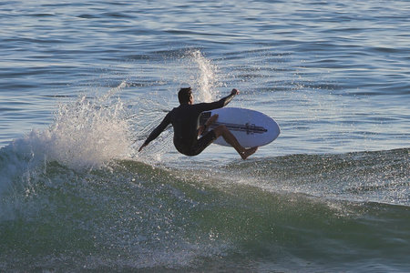 Surfer in action at the beach on a beautiful sunny day.