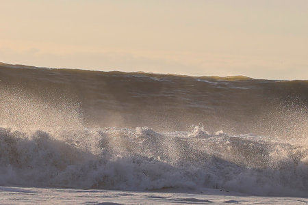 Beautiful sunset on the beach in winter with a wave in the foreground