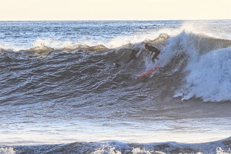 Surfer in action on the ocean waves on a sunny day.