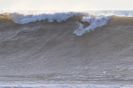 Big wave breaking on a sandy beach in the Pacific Ocean in Californiaの写真素材