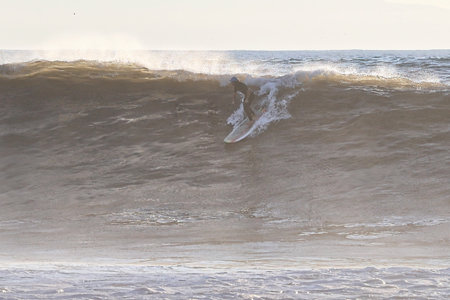 Surfer in action on the ocean waves on a sunny day.