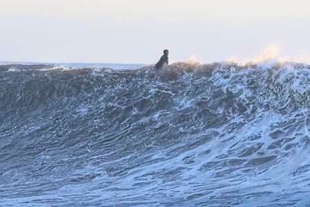 Surfer on a stormy day at the beach in winter.の写真素材