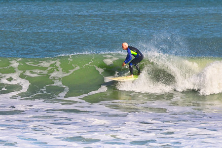 Surfer in action on the ocean waves on a sunny day.