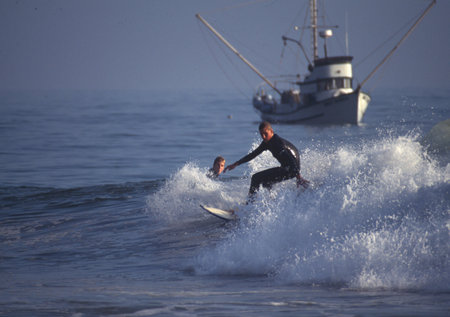 Surfer in action on the beach of Nazare, Portugal.
