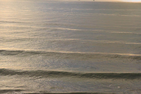 Sea waves on the beach at sunset, closeup of photo.
