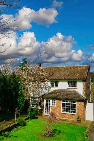 Beautiful English country cottage on a sunny day with a blue skyの写真素材