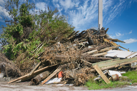 Pile of broken wooden boards on the street. Damaged building