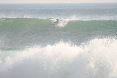 Surfer in action at the end of the wave on a sunny day.