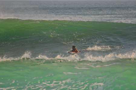 Surfer in the ocean on a beautiful sunny day, Bali, Indonesia