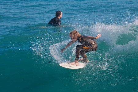 Surfer girl in action on the surfboard at the beach.