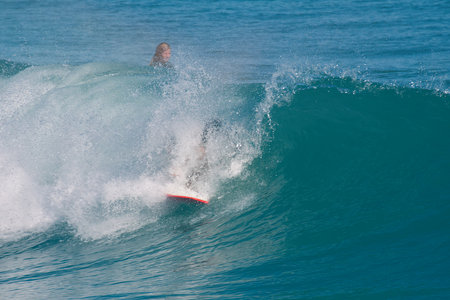 Bodyboarder in action on the ocean wave on a sunny day.