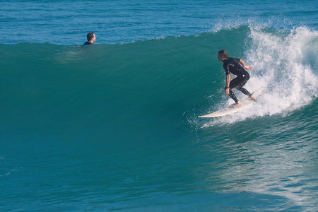 Surfer in action on the ocean wave on a sunny day.