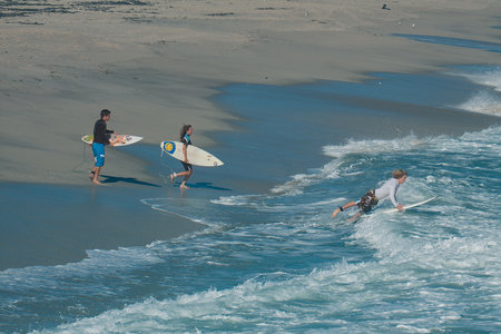 Surfers on the beach of Playa de las Conchas in Fuerteventura, Canary Islands, Spain