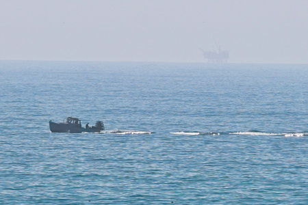 Tugboat in the sea on the background of the oil rig