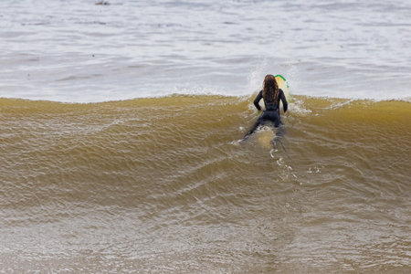 Surfer with his surfboard in the sea. Shallow depth of fieldの写真素材