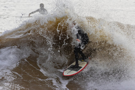 Surfer in action on the beach. Surfer on the wave.