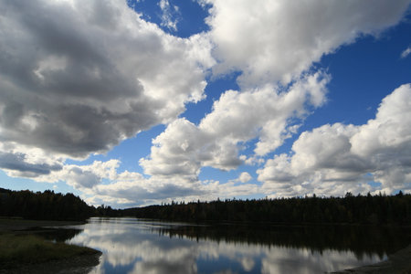 Clouds reflected in the water of a lake in Yakutiaの写真素材