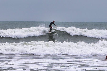 Surfer in action at the beach in Nazare, Portugal.