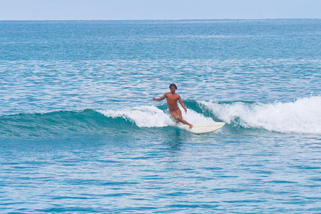 Surfer on the ocean wave in sunny day. Bali, Indonesiaの写真素材