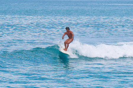 Surfer on Blue Ocean Wave, Bali Island, Indonesia.