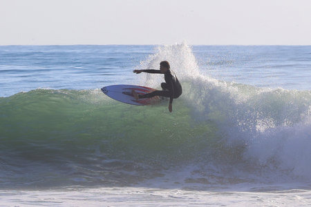 Surfer in action on the ocean wave on a sunny day.の写真素材