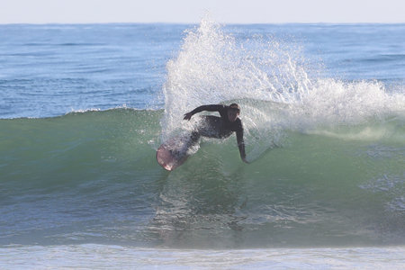 Surfer in action on a beautiful sunny day at the beach.