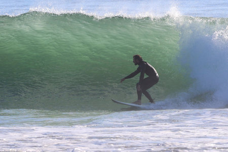 Surfer in action on the ocean wave on a sunny day.