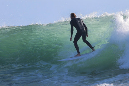 Surfer in action on the ocean wave on a sunny day.