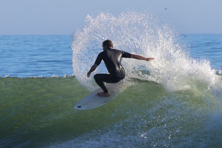 Surfer in action on the ocean wave on a sunny day.