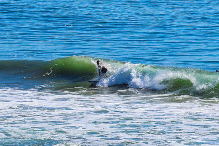 Surfer on the beach in Malibu, California, USA.