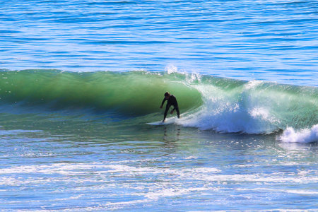 Surfer in the ocean on a beautiful sunny day. Spain.