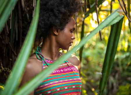 Melanesian pacific islander athlete girl with afro hair sytile in the jungle, half profileの写真素材