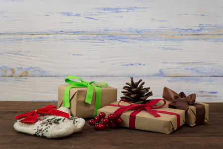 Packages with gifts, knitted baby socks, a red bow, a cone, a twig of the viburnum.の写真素材