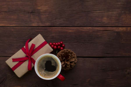 Packaging with a gift, a cup of coffee with a heart, a viburnum, a fir-cone.の写真素材