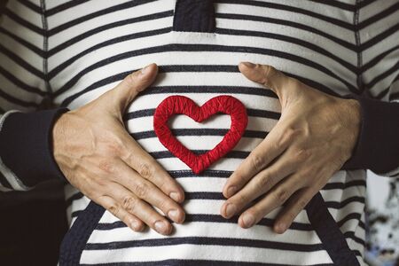 Heart and hands of the guy on a sweater.の写真素材