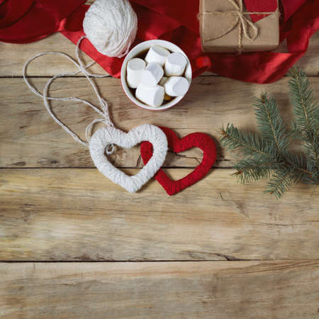 Gift with heart, marshmallow, red ribbon and two hearts handmade on wooden background. Valentine's Day concept.の写真素材