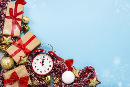 Red alarm clock, Christmas decorations, gifts on a blue background. Merry Christmas and happy new...