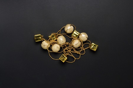 Garland golden color on a black background. The concept of New Year and Merry Christmas. Minimalism. Flat lay, top view.の写真素材